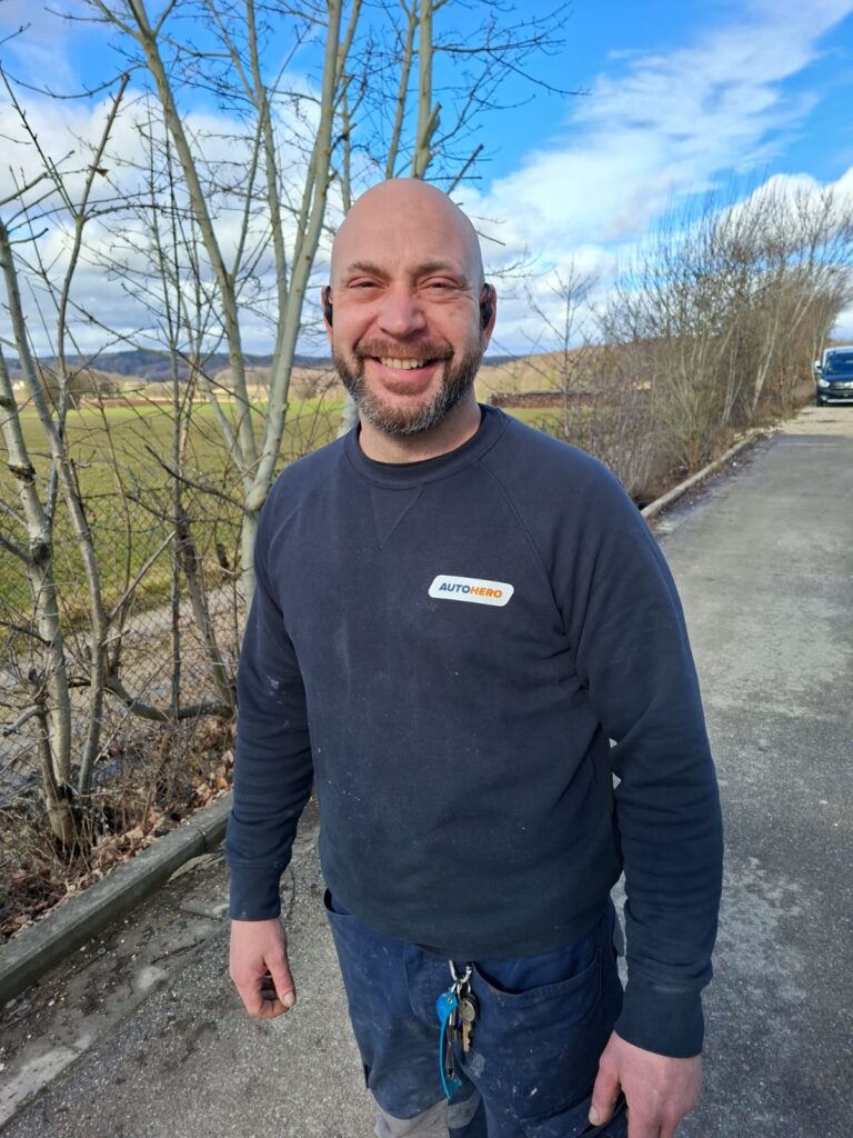 Noé Serrano sonriendo con ropa de trabajo en el taller de pintura analizando la libertad financiera.