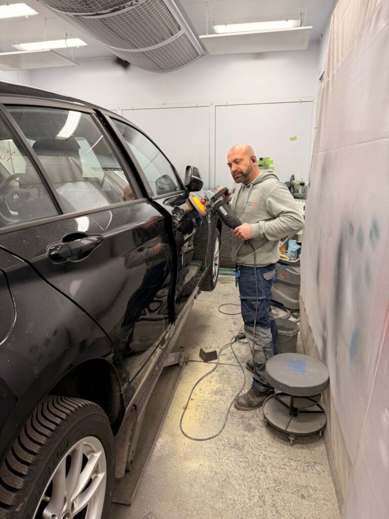 Noé Serrano puliendo un coche en su box de pintura de Alemania preparando su hoja de ruta 2032.