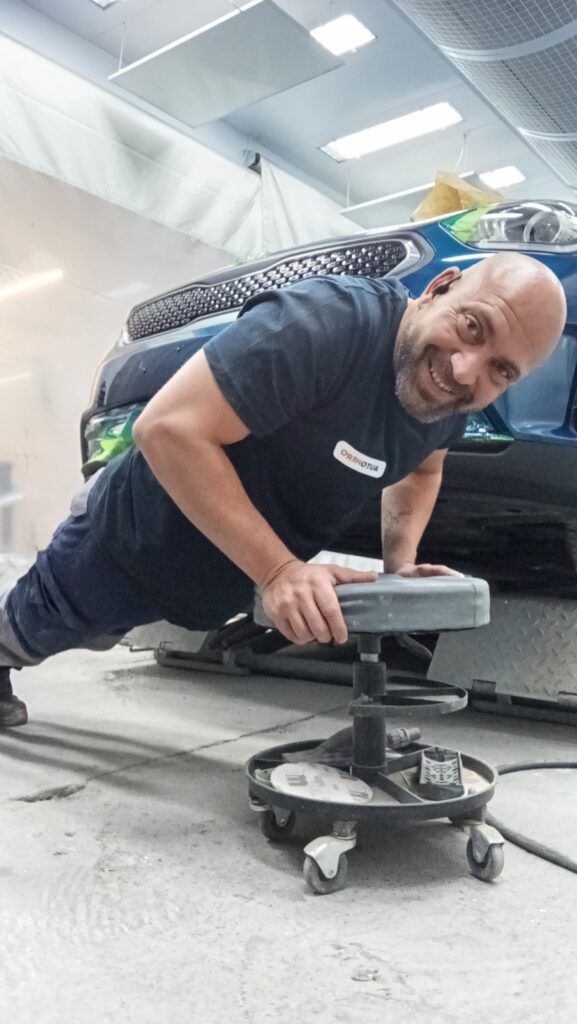 Noé haciendo flexiones en el suelo del box de pintura mientras seca el color de un coche