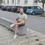 Noé Serrano revisando el móvil en una calle de Hemau, Alemania, justo después de completar el trámite de autónomo y descargar la app Elster