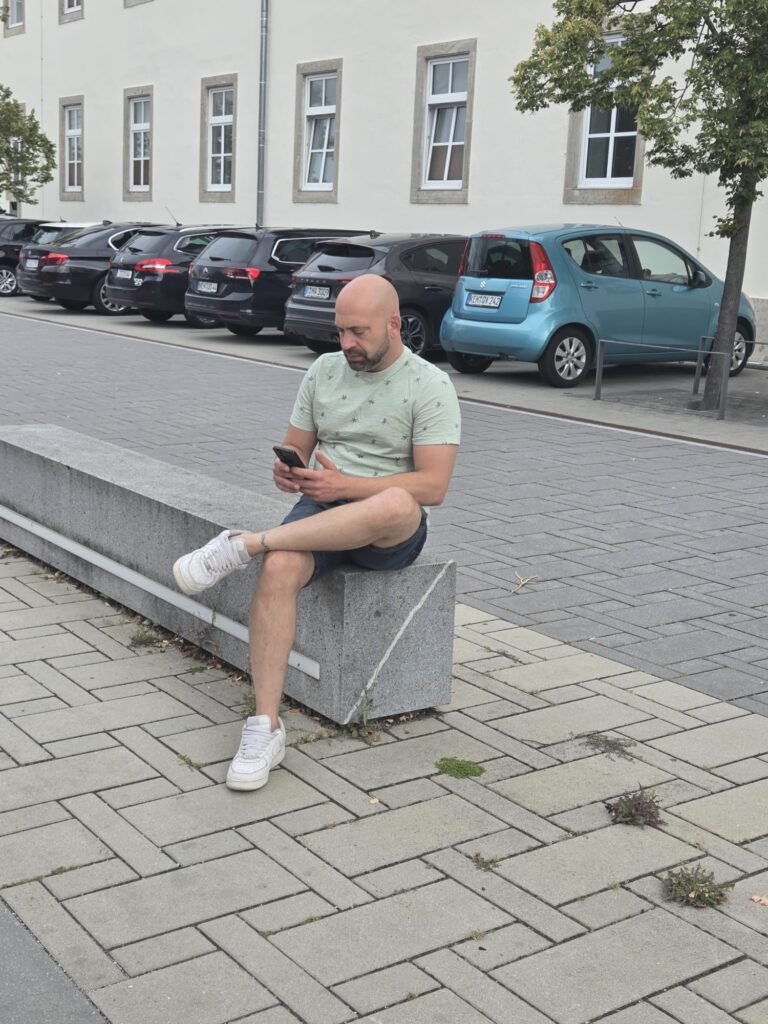 Noé Serrano revisando el móvil en una calle de Hemau, Alemania, justo después de completar el trámite de autónomo y descargar la app Elster