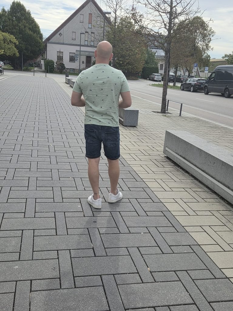 Noé Serrano caminando de espaldas por una acera en Alemania, simbolizando el camino de superación del analfabetismo digital en Ruta 2032.