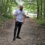 Noé Serrano caminando pensativo por un sendero en el bosque, reflexionando sobre por qué no quiere jubilarse nunca