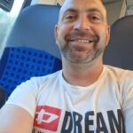Noé Serrano sonriendo en un tren camino a Hemau, Alemania, reflejando el día a día real de empezar de cero en otro país.