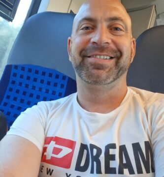 Noé Serrano sonriendo en un tren camino a Hemau, Alemania, reflejando el día a día real de empezar de cero en otro país.